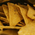 A detailed view of crispy nacho chips inside a metallic snack package.